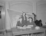 Three Booklovers Association officers in front of campus map